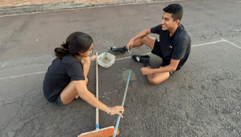 Students in Galapagos fill a pothole with " bio concrete" they created through project-based learning.
