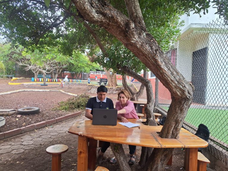 Miriam Chacón and teacher-coach Alexis Alcán review a lesson plan together in Galapagos.
