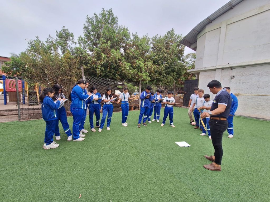 Students in Galapagos are engaged in a hands-on lesson outside in their school courtyard.